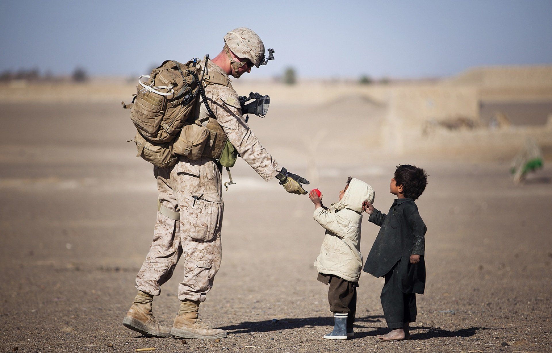 Soldier helping young children