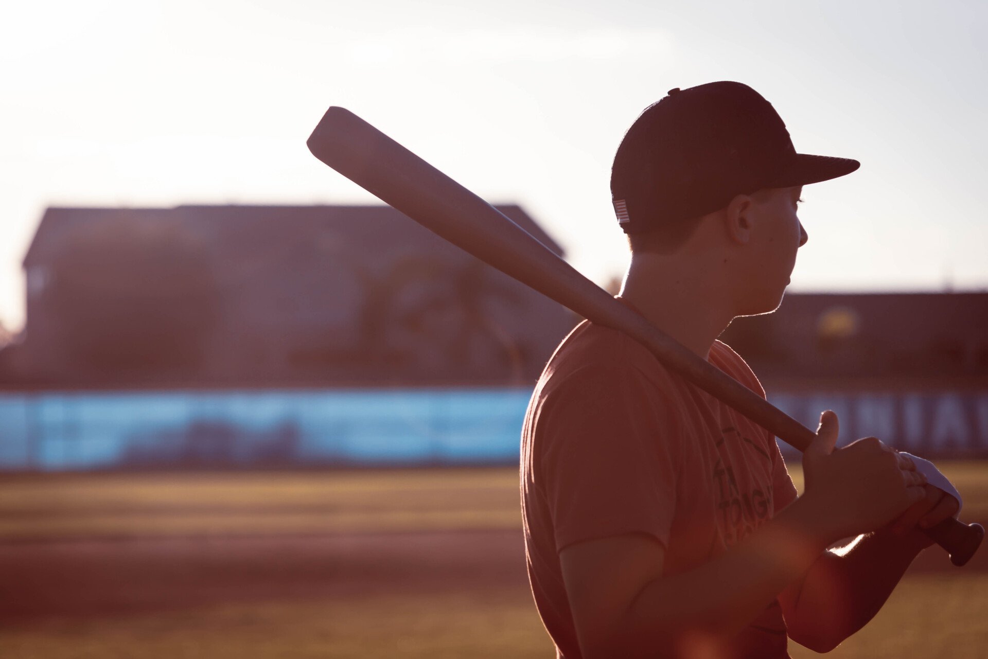 A baseball player with the number 4 on his jersey is swinging at a ball