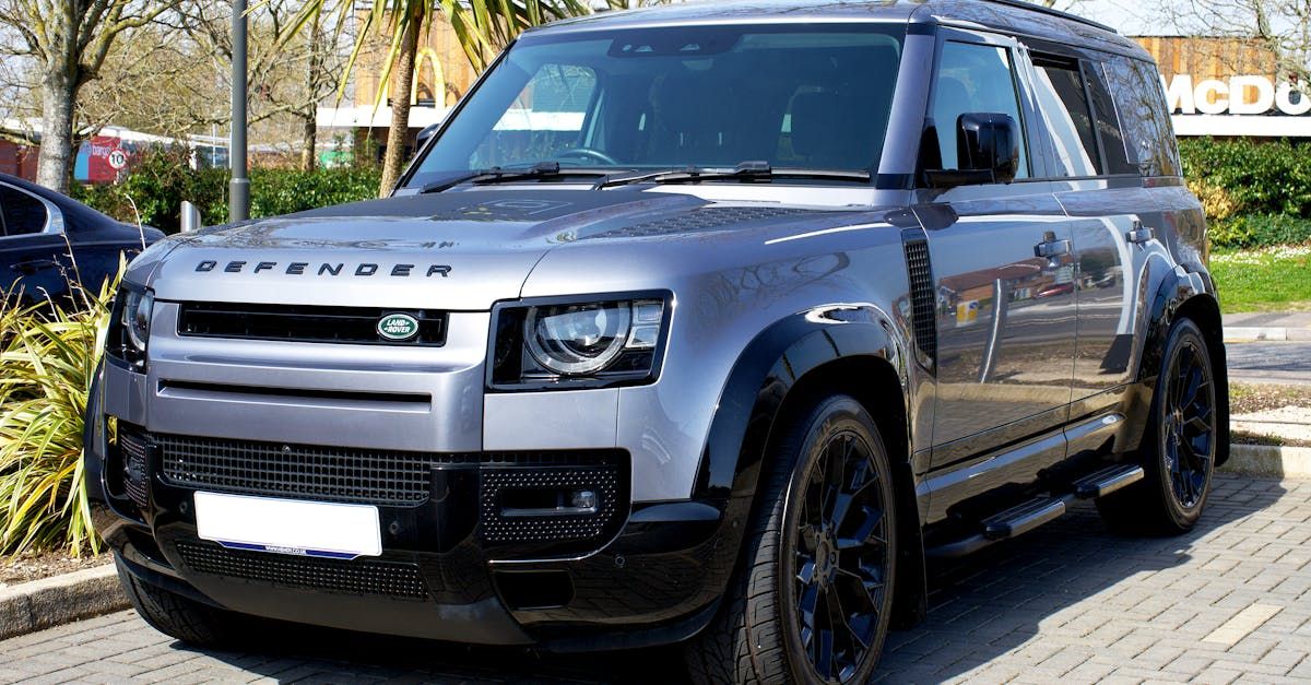 Silver Land Rover Defender SUV parked outdoors.