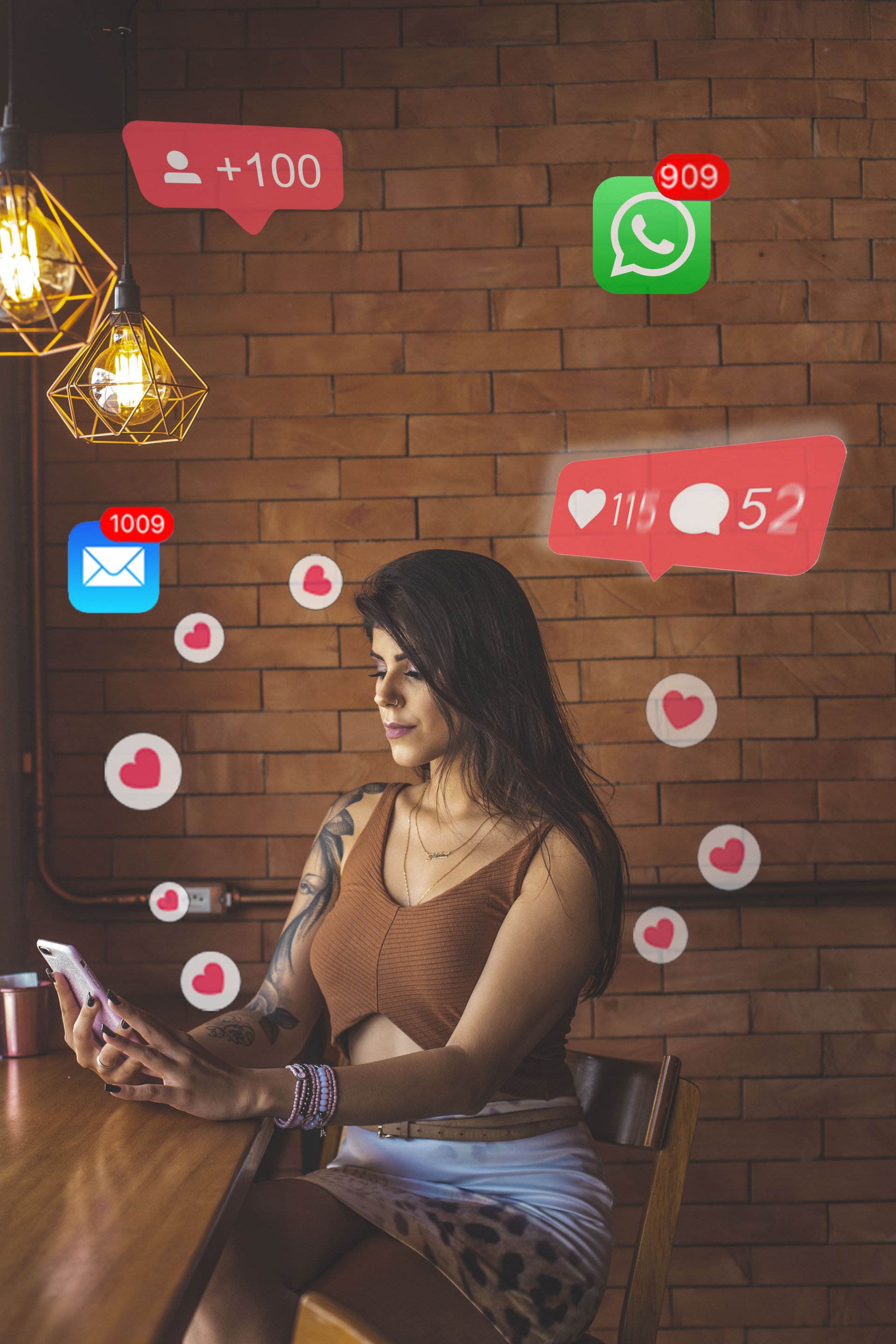 A woman is sitting at a table looking at her phone.