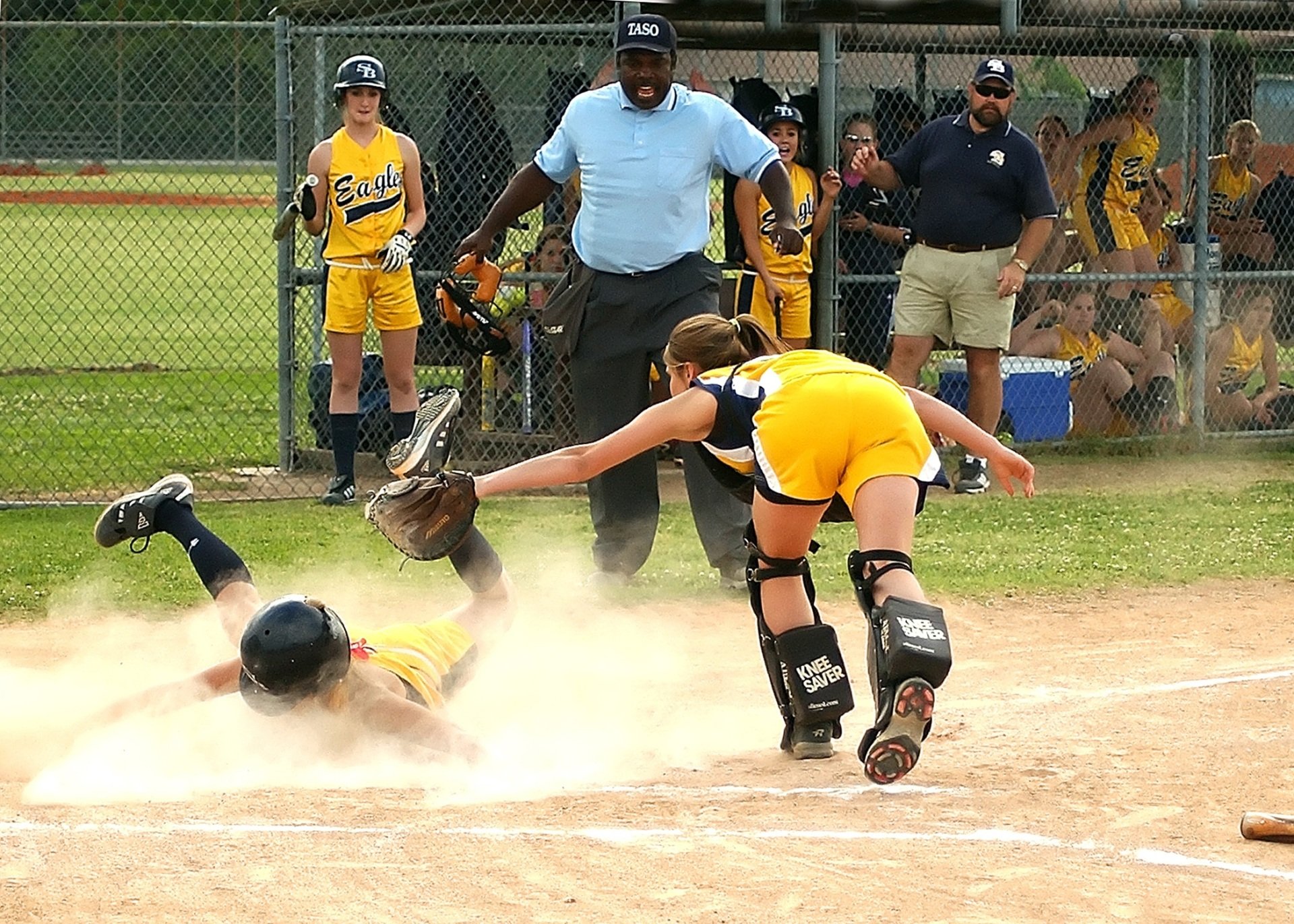 A girl is sliding into base during a softball game