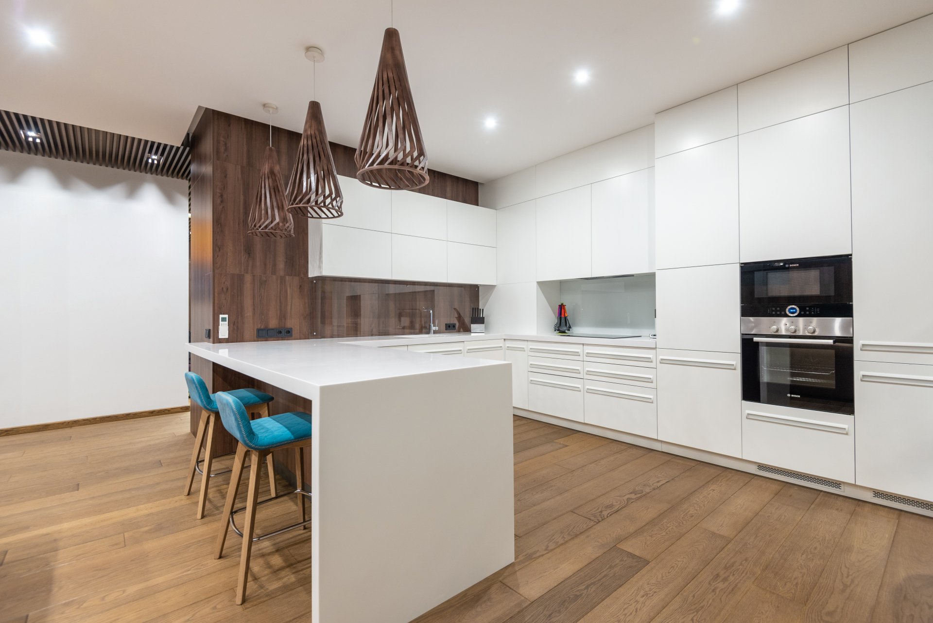 a kitchen with white cabinets , wooden floors , and a large island .