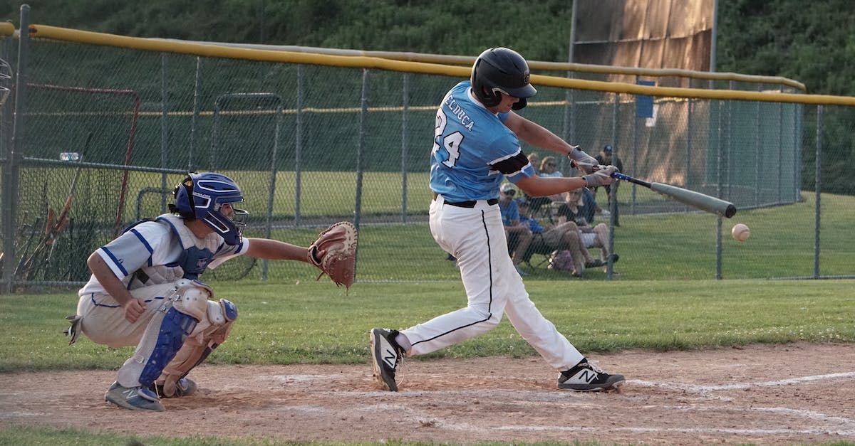 A man and a boy are standing on a baseball field talking to each other.