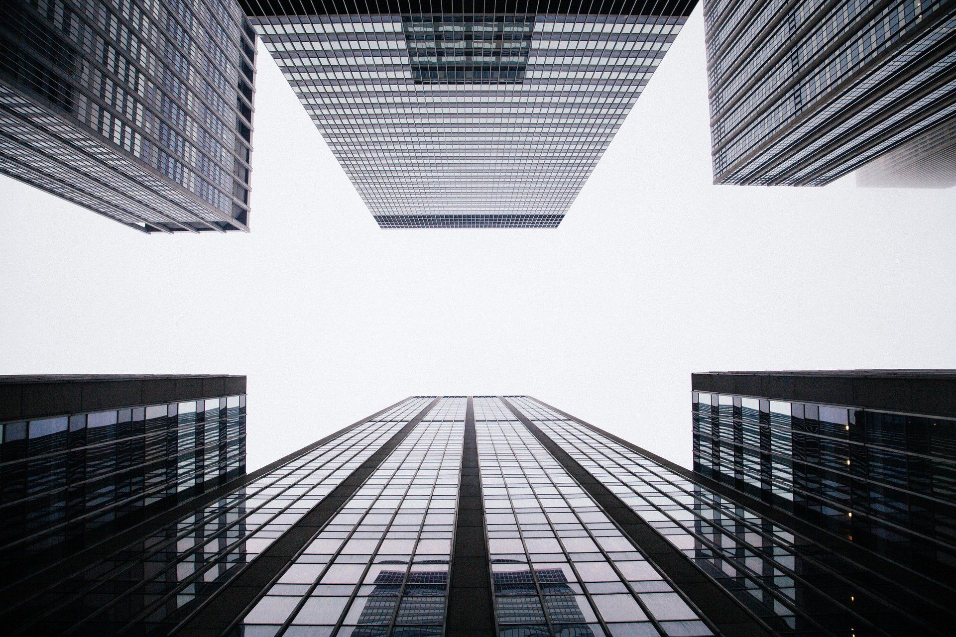 Looking up at a group of tall buildings with a white background.