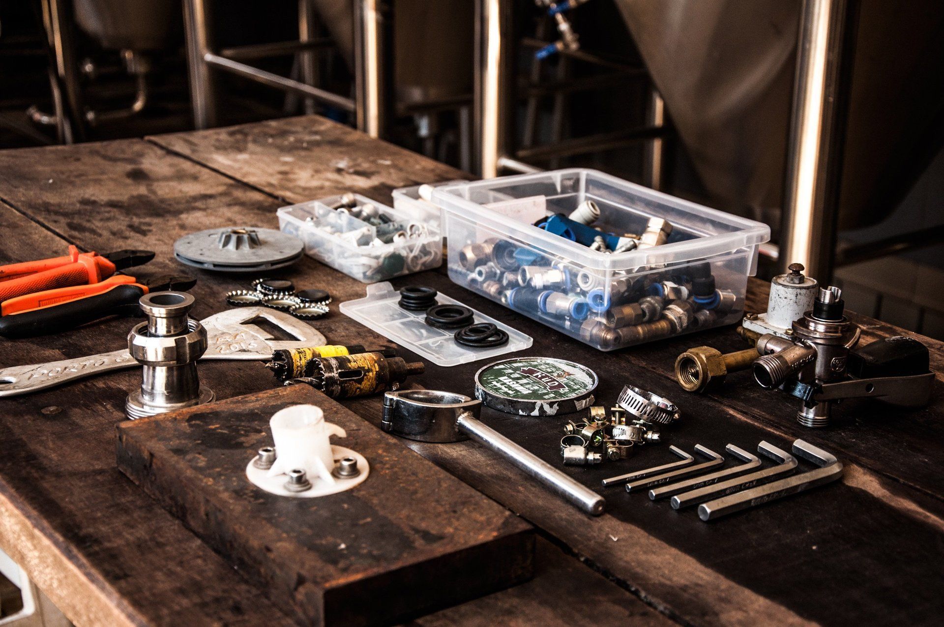 A wooden table topped with a variety of tools and nuts.