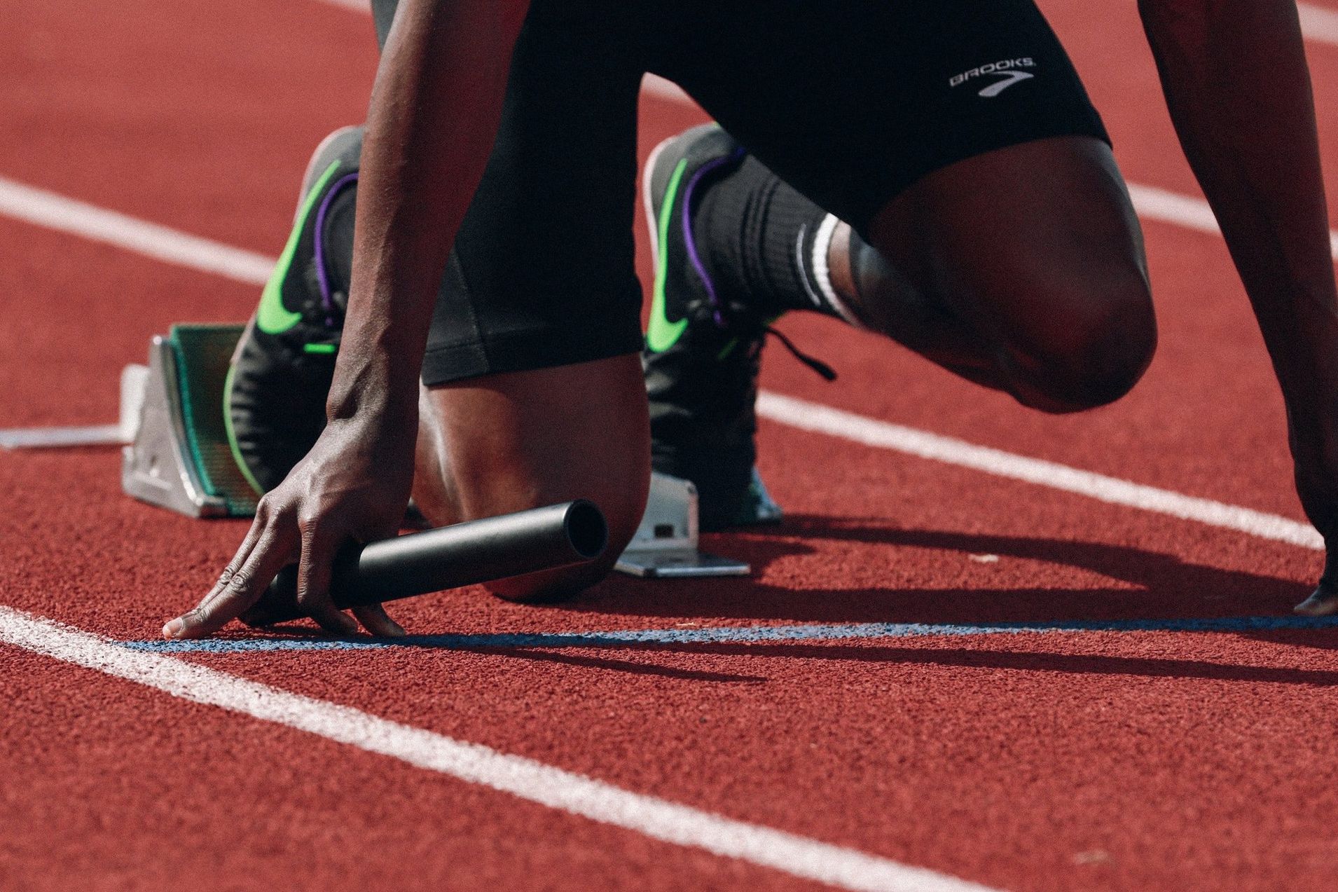 A runner is getting ready to run on a track.