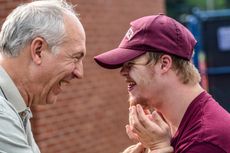 A man and a young man are laughing at each other.