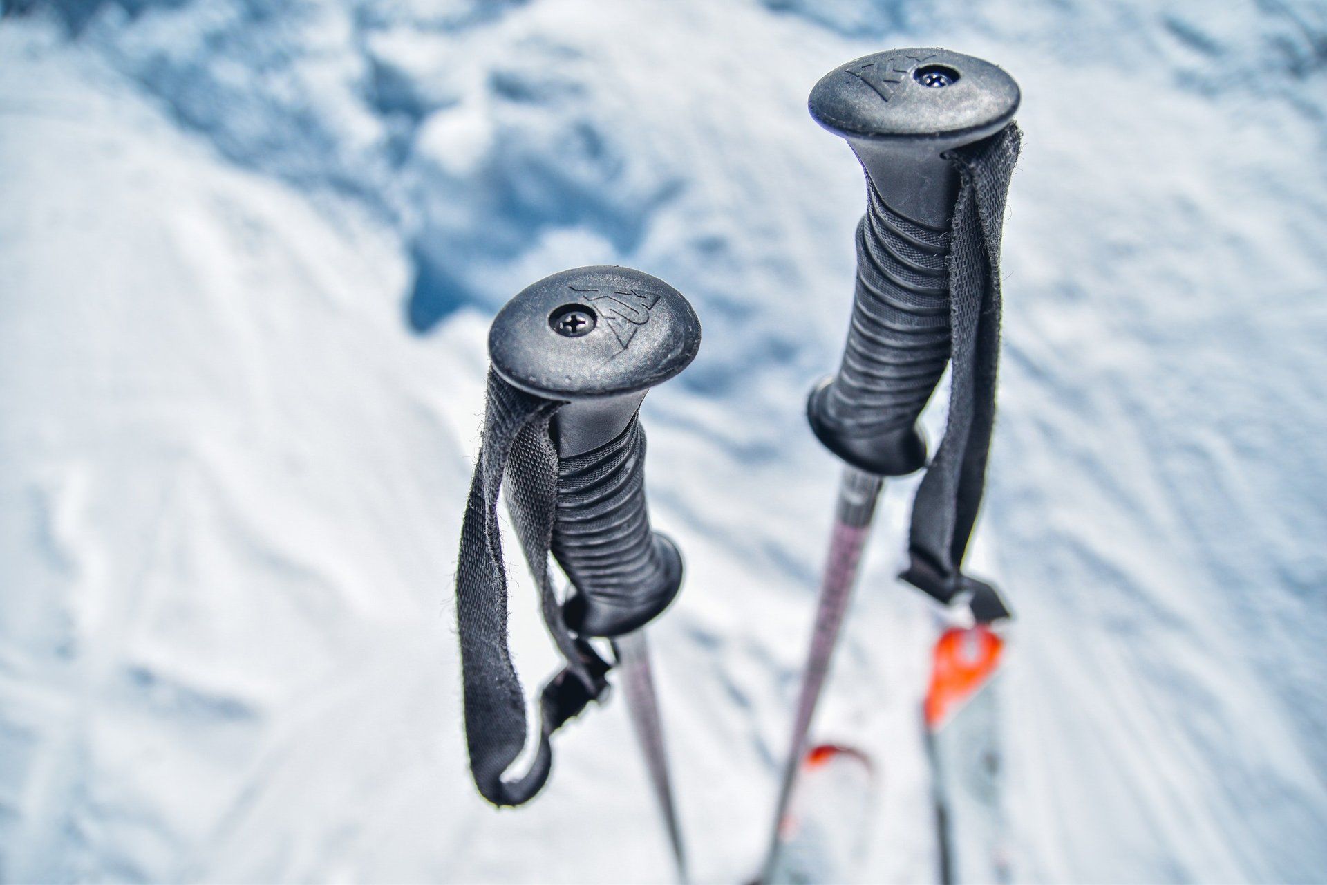 A pair of ski poles sitting on top of a snow covered slope.