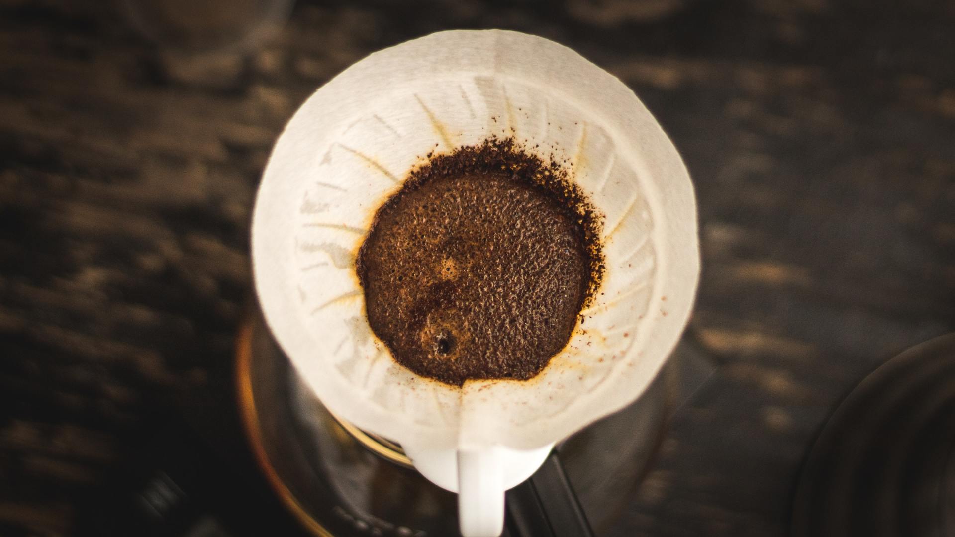 Um close de um filtro de café com café sendo derramado nele.