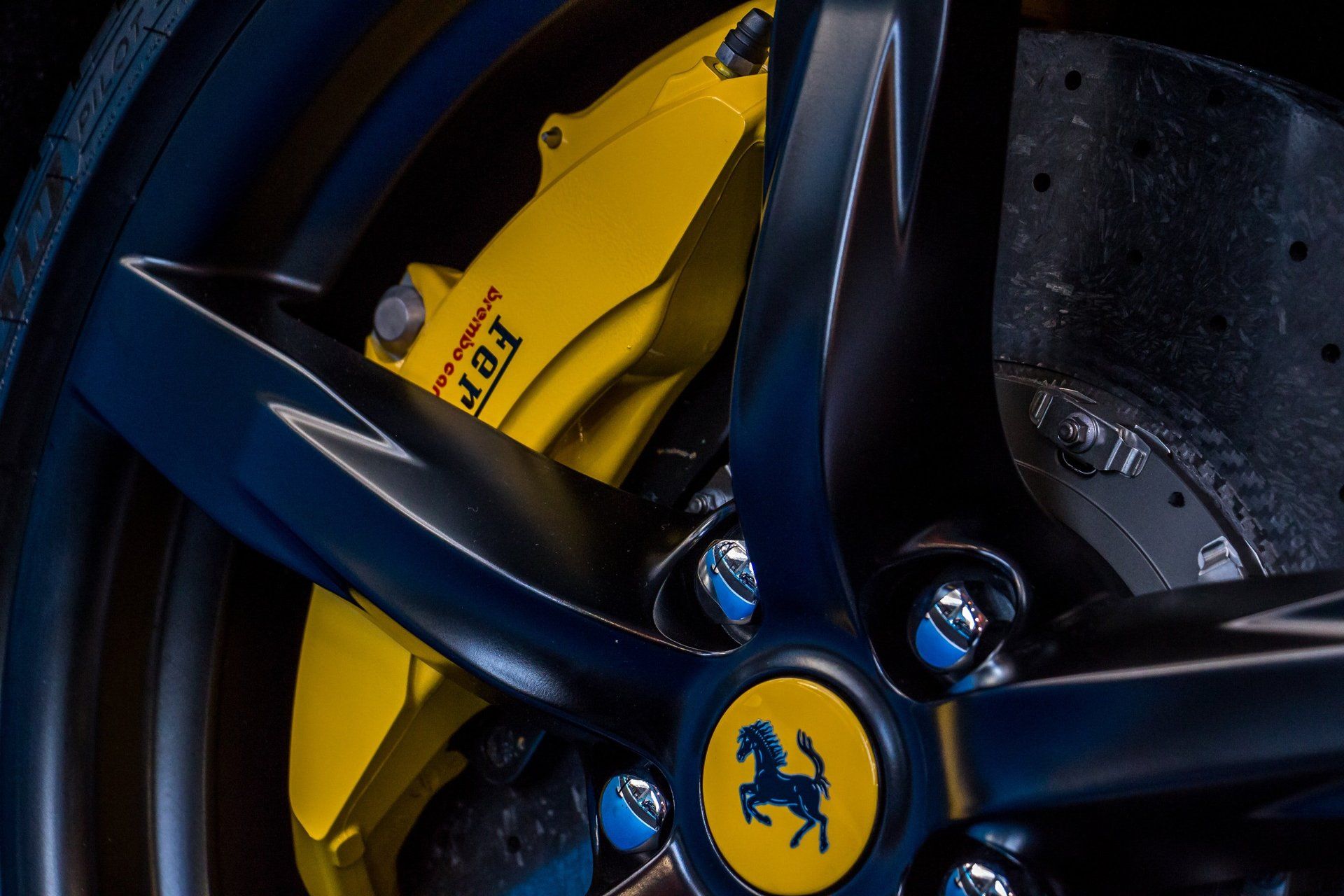 a close up of a ferrari wheel with a yellow brake caliper