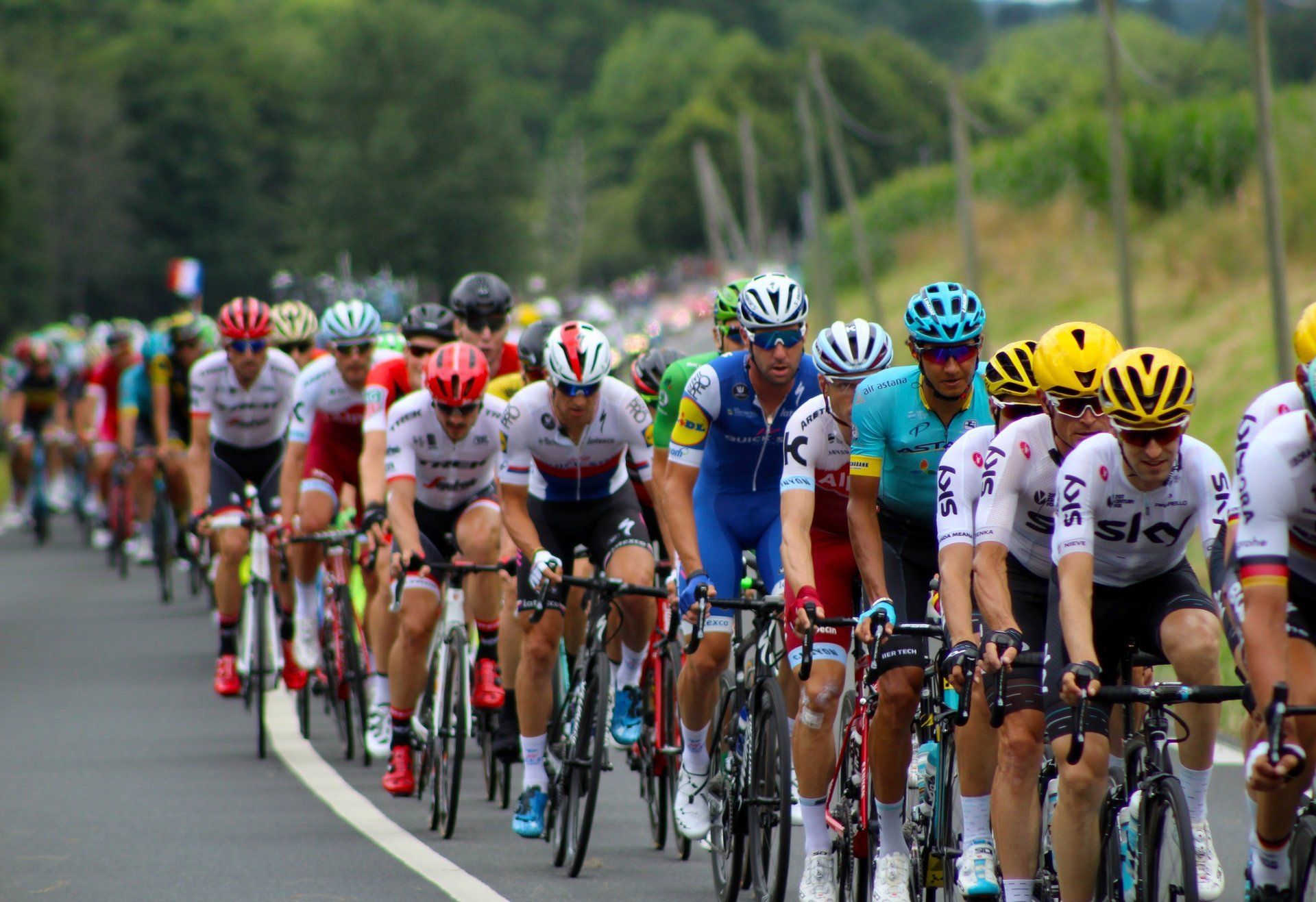 A group of cyclists are riding down a road.