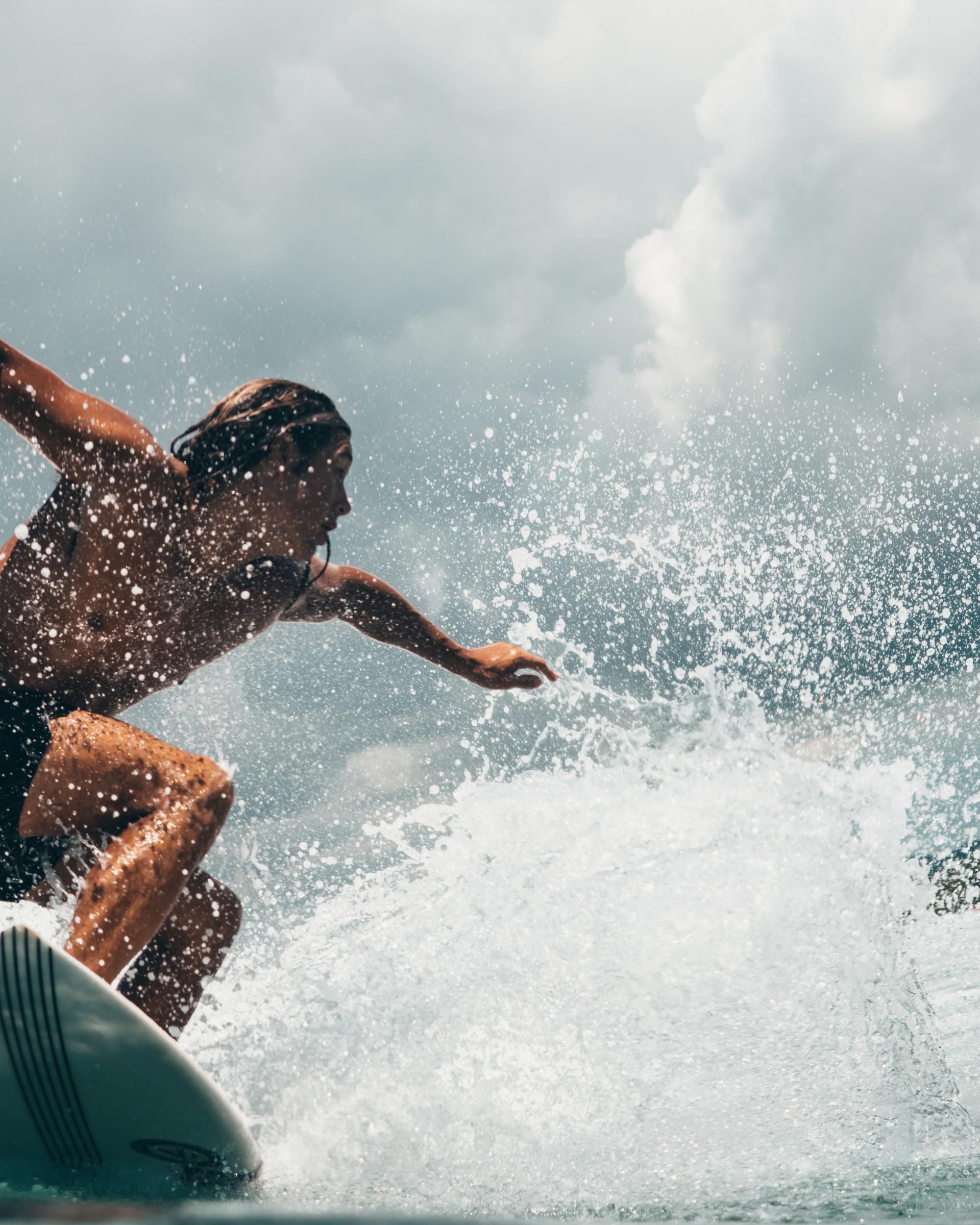 A man is riding a wave on a surfboard in the ocean.