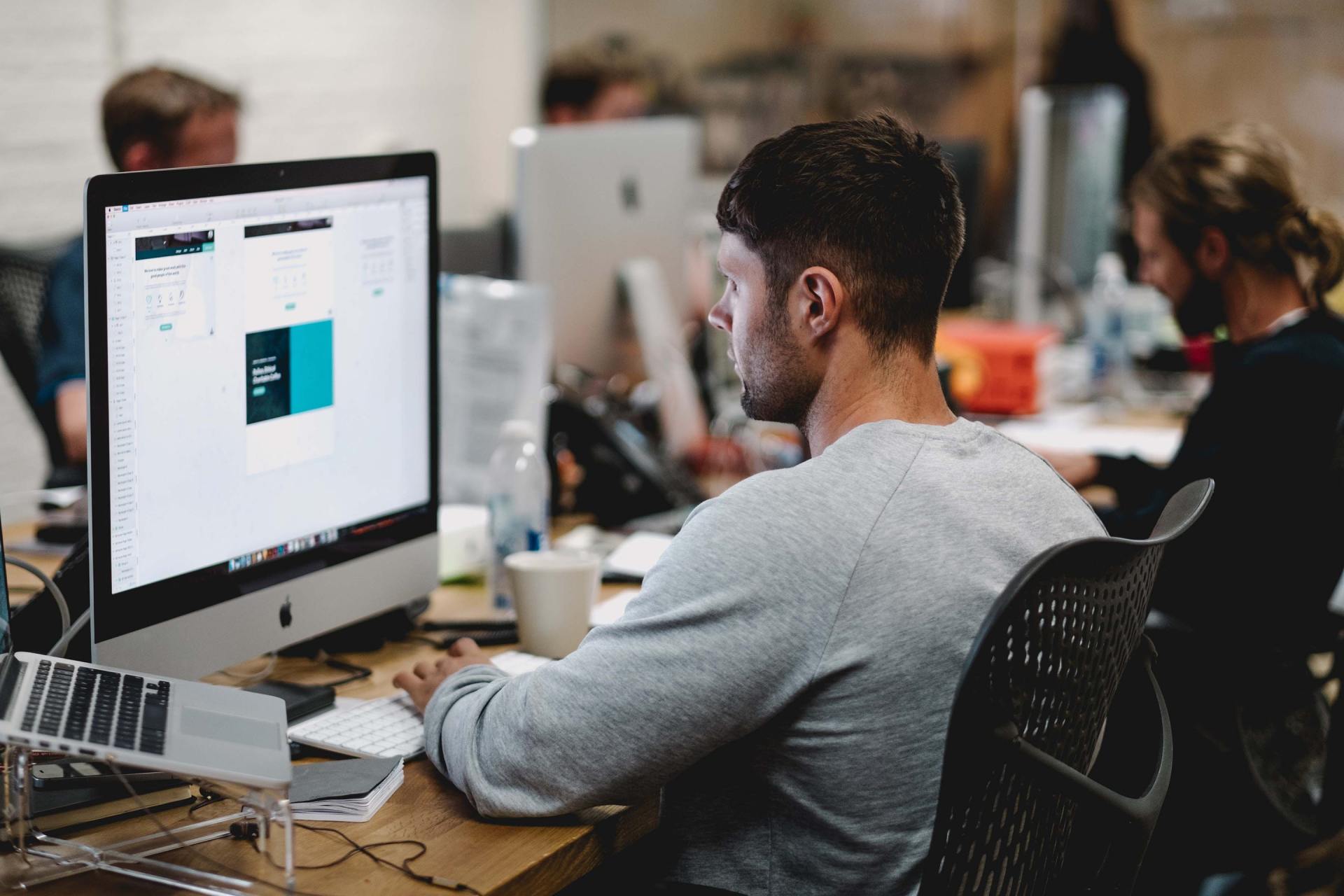 A man is sitting at a desk in front of a computer.
