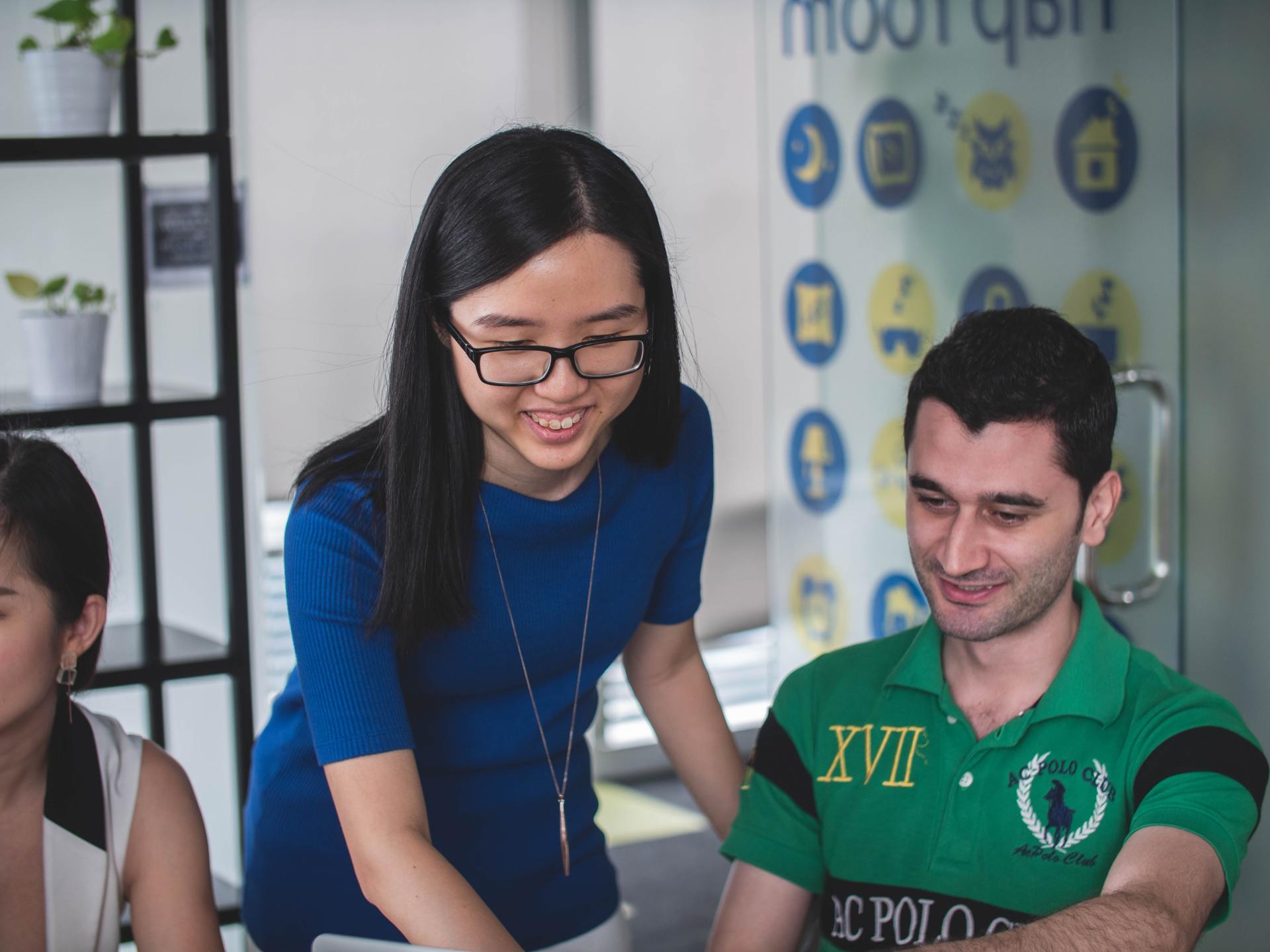 A woman is standing next to a man in a green polo shirt.
