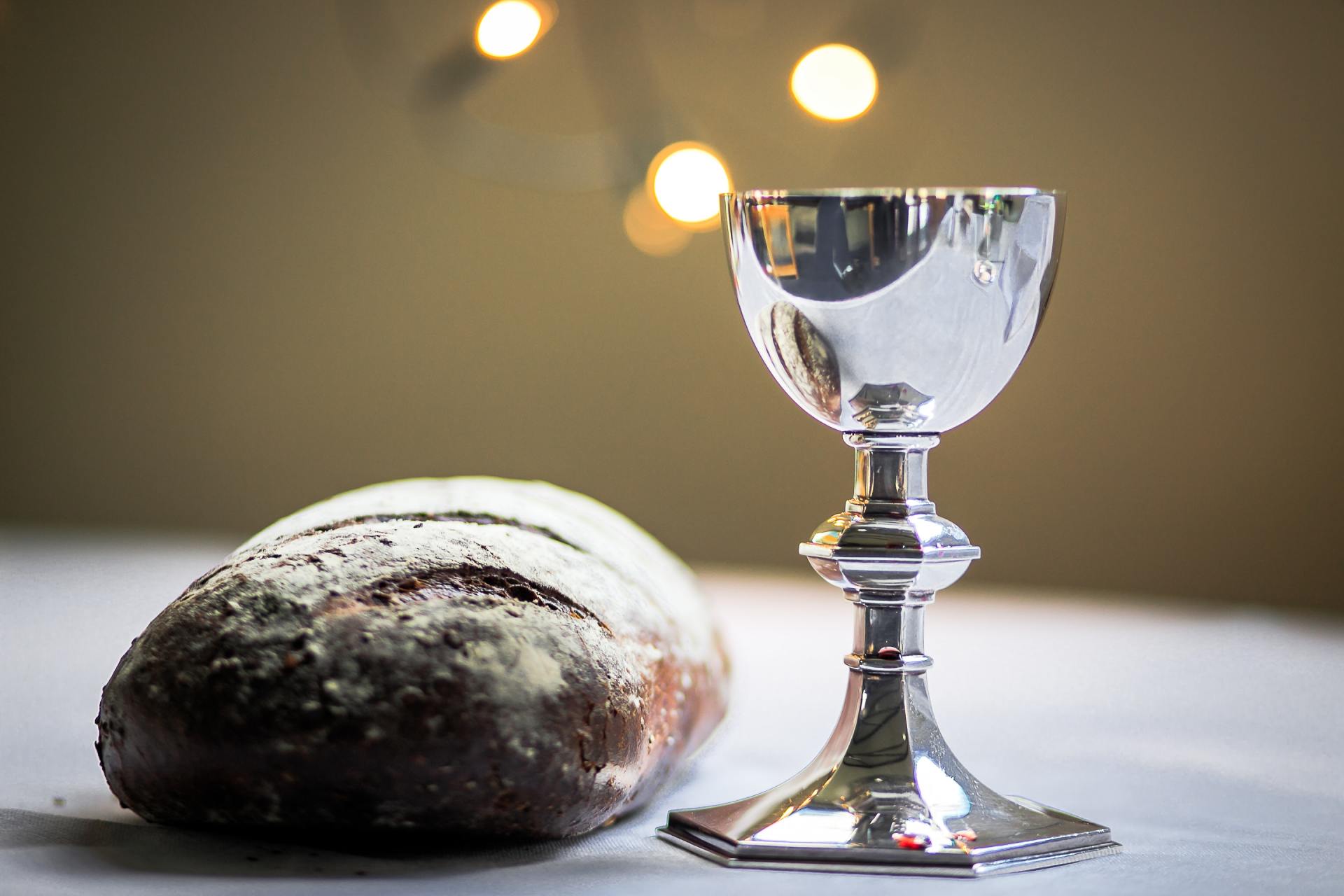 A loaf of bread and a chalice on a table.
