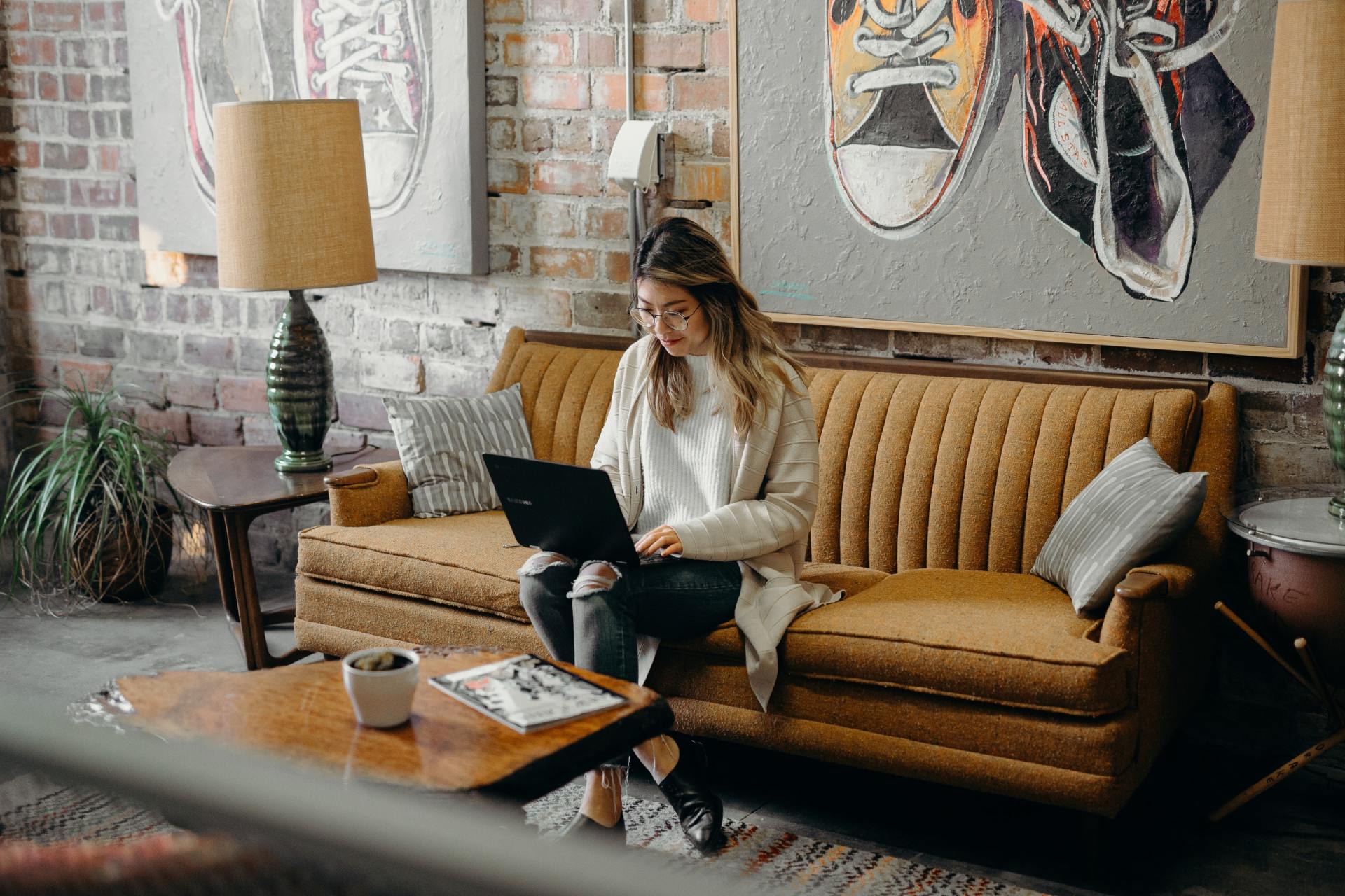 female checking email on her computer while sitting on a couch