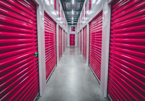 Un long couloir bordé de portes de rangement rose vif.