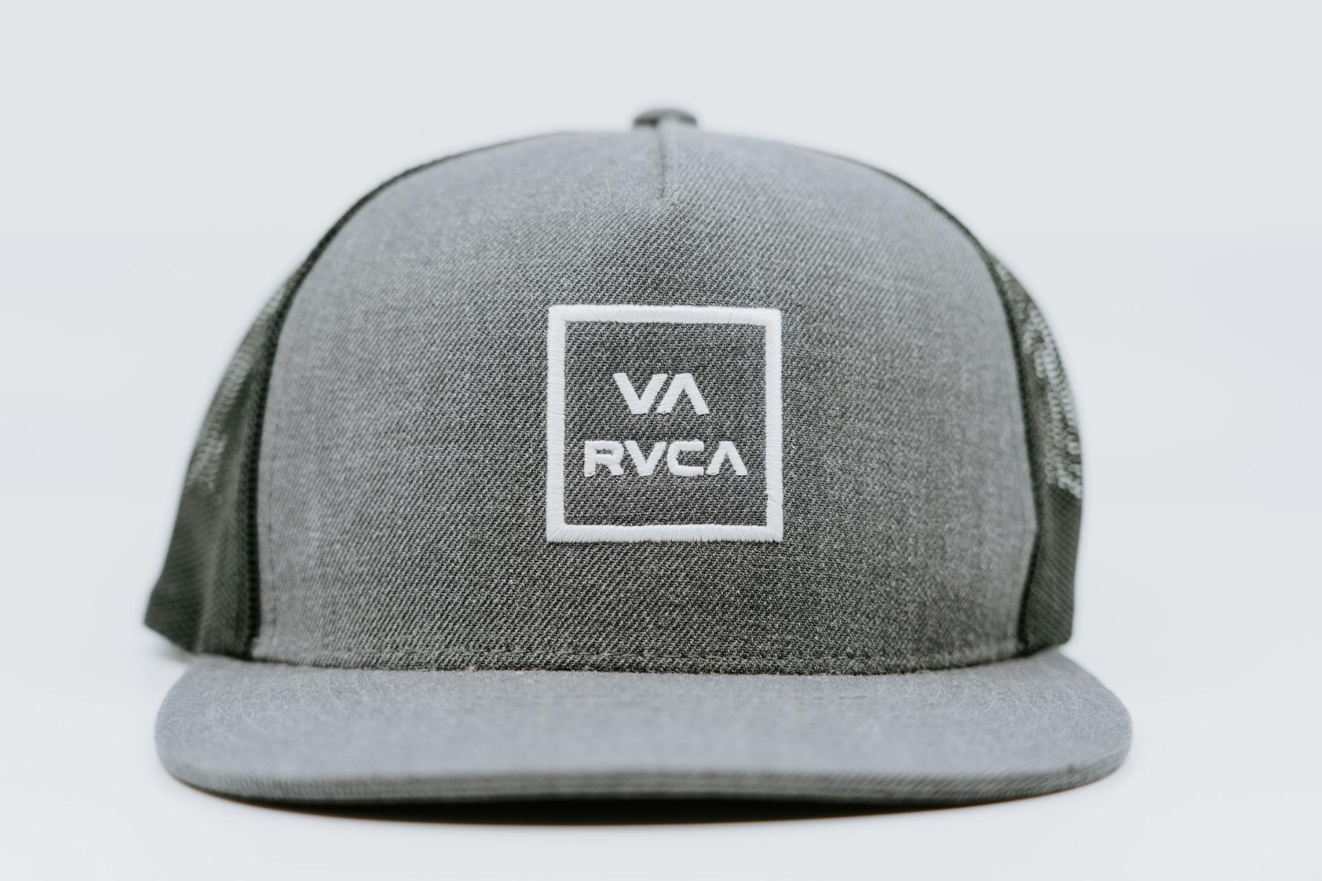 A grey hat with a white square on the front
