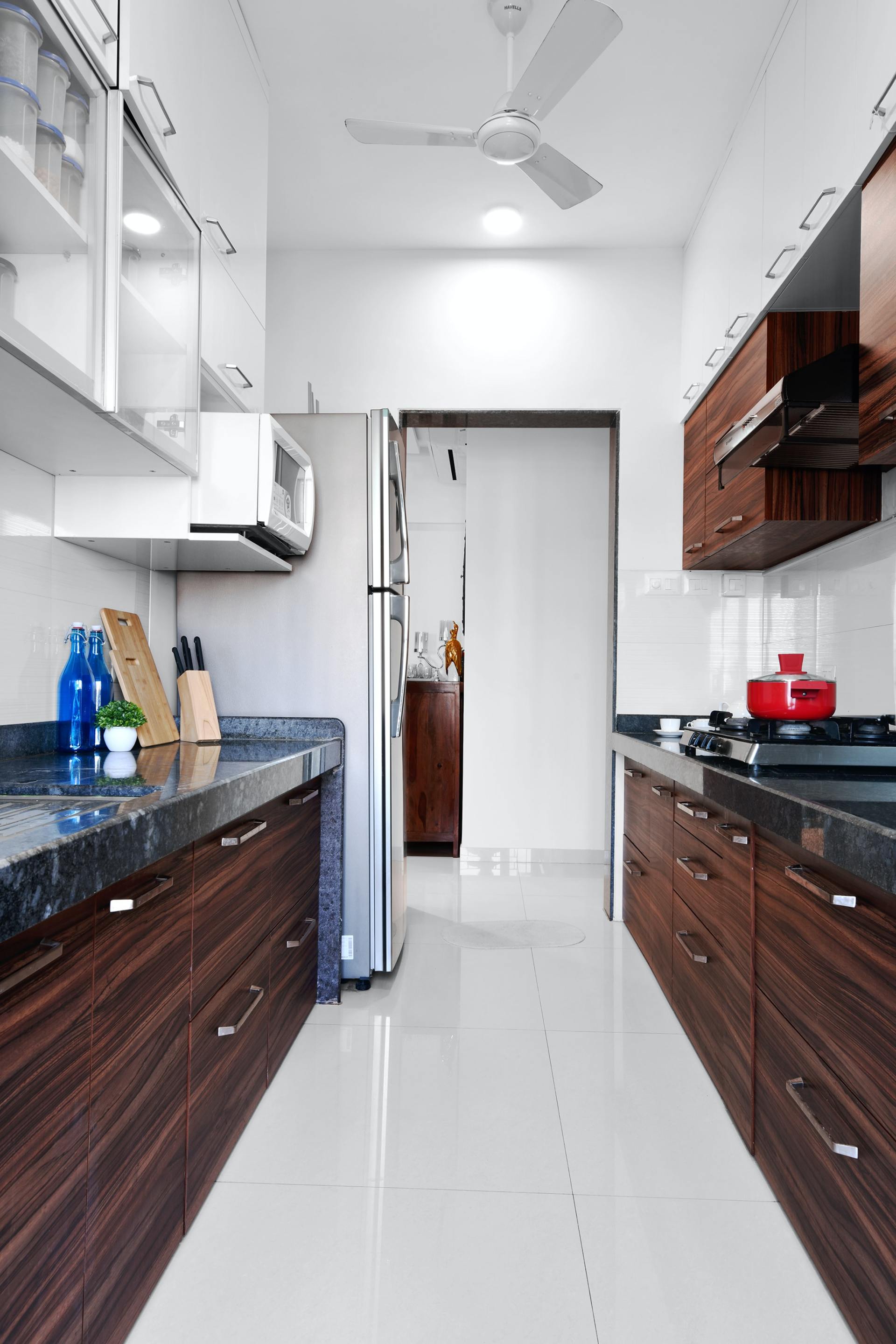 A kitchen with wooden cabinets and a ceiling fan.