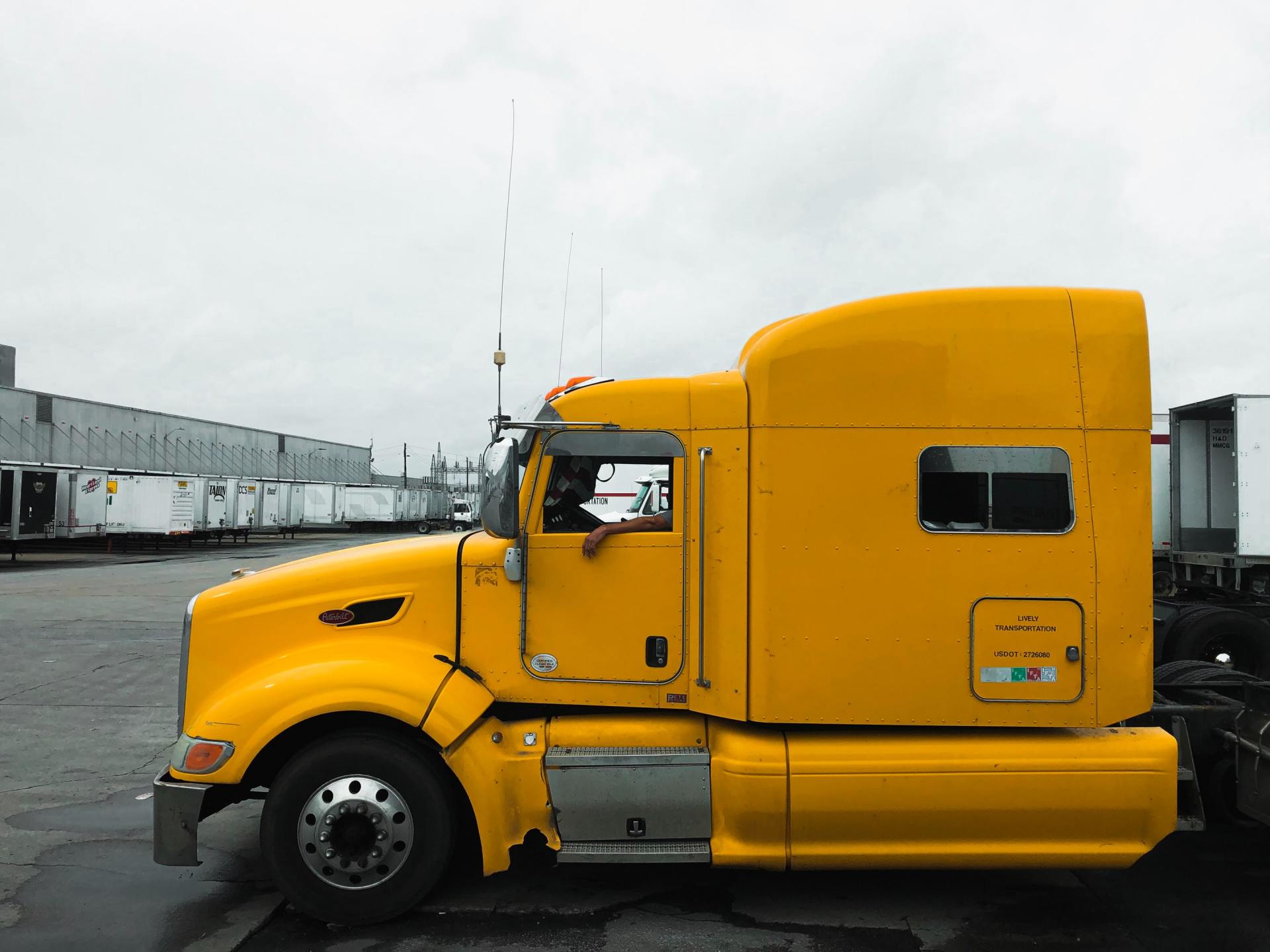 A yellow semi truck is parked in a parking lot.