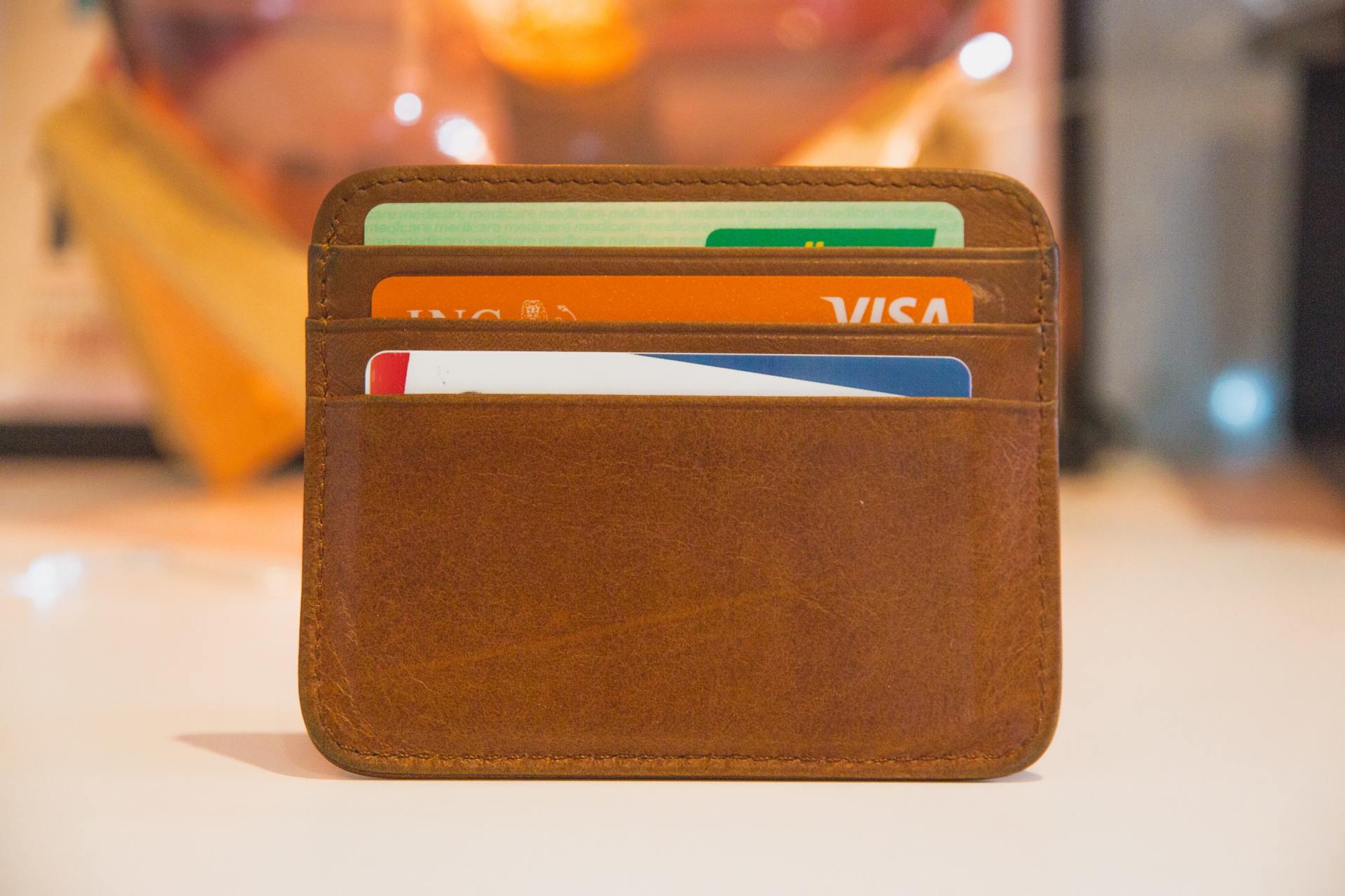 Brown leather wallet with credit cards partially visible on a table