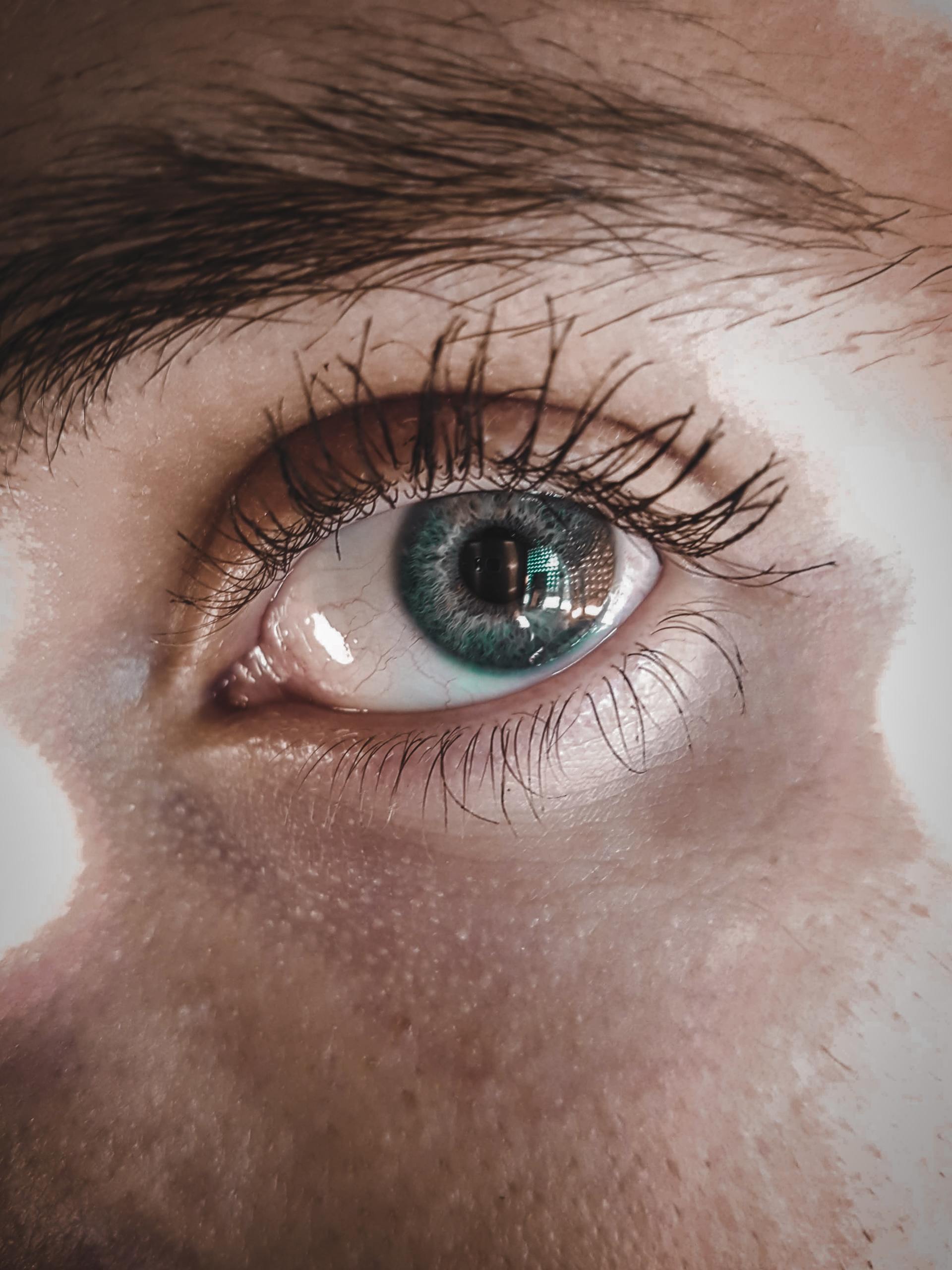 A close up of a person 's blue eye with mascara.