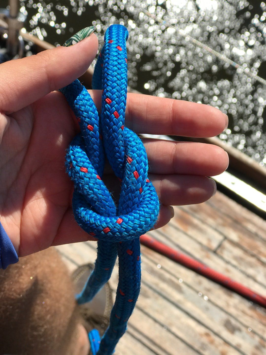Eine Person hält ein blaues Seil in der Hand