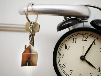a key hanging in front of a clock