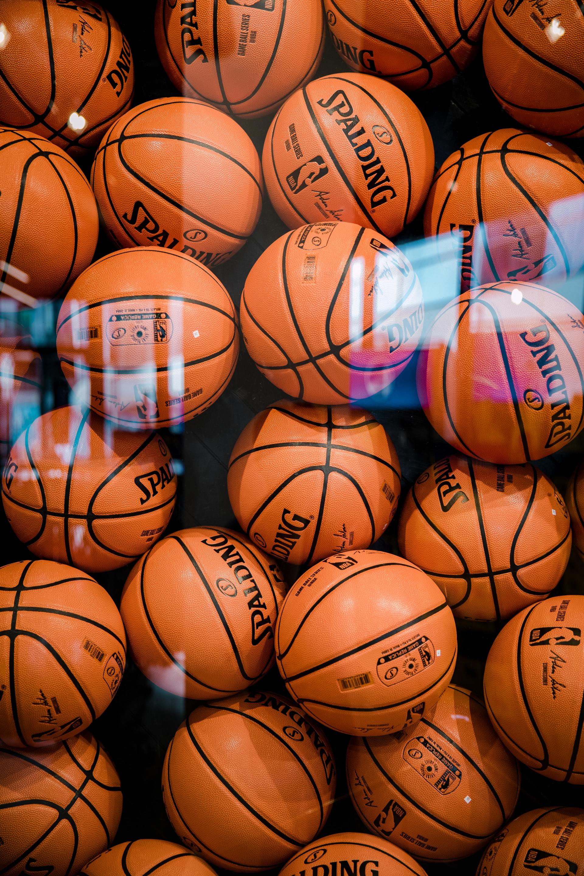 Pile of orange basketballs stacked together in a close-up view