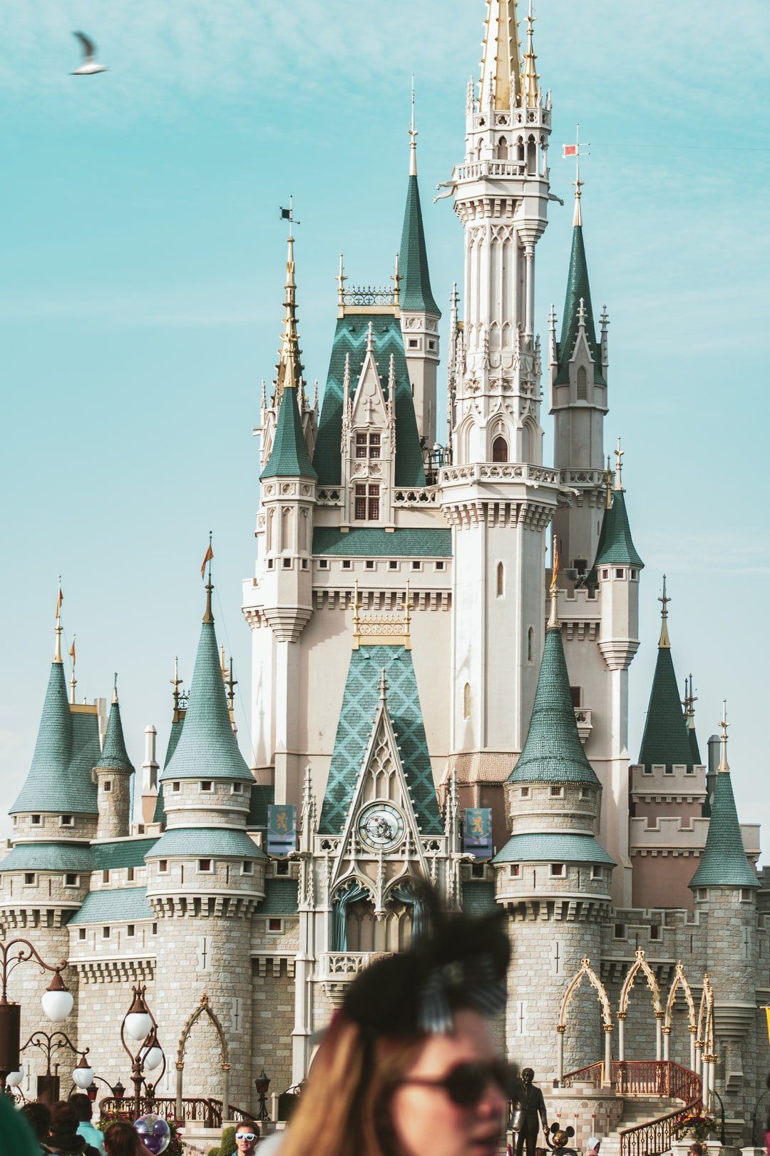 A woman is walking in front of a large castle