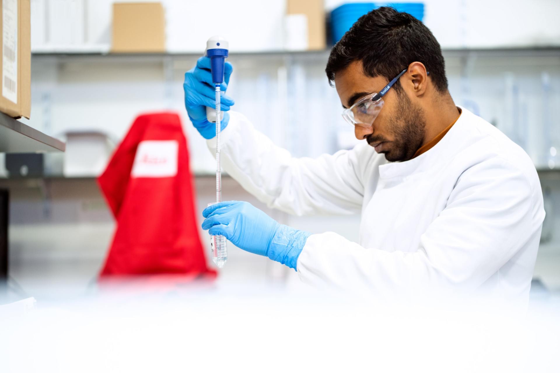 A scientist is using a pipette in a laboratory.