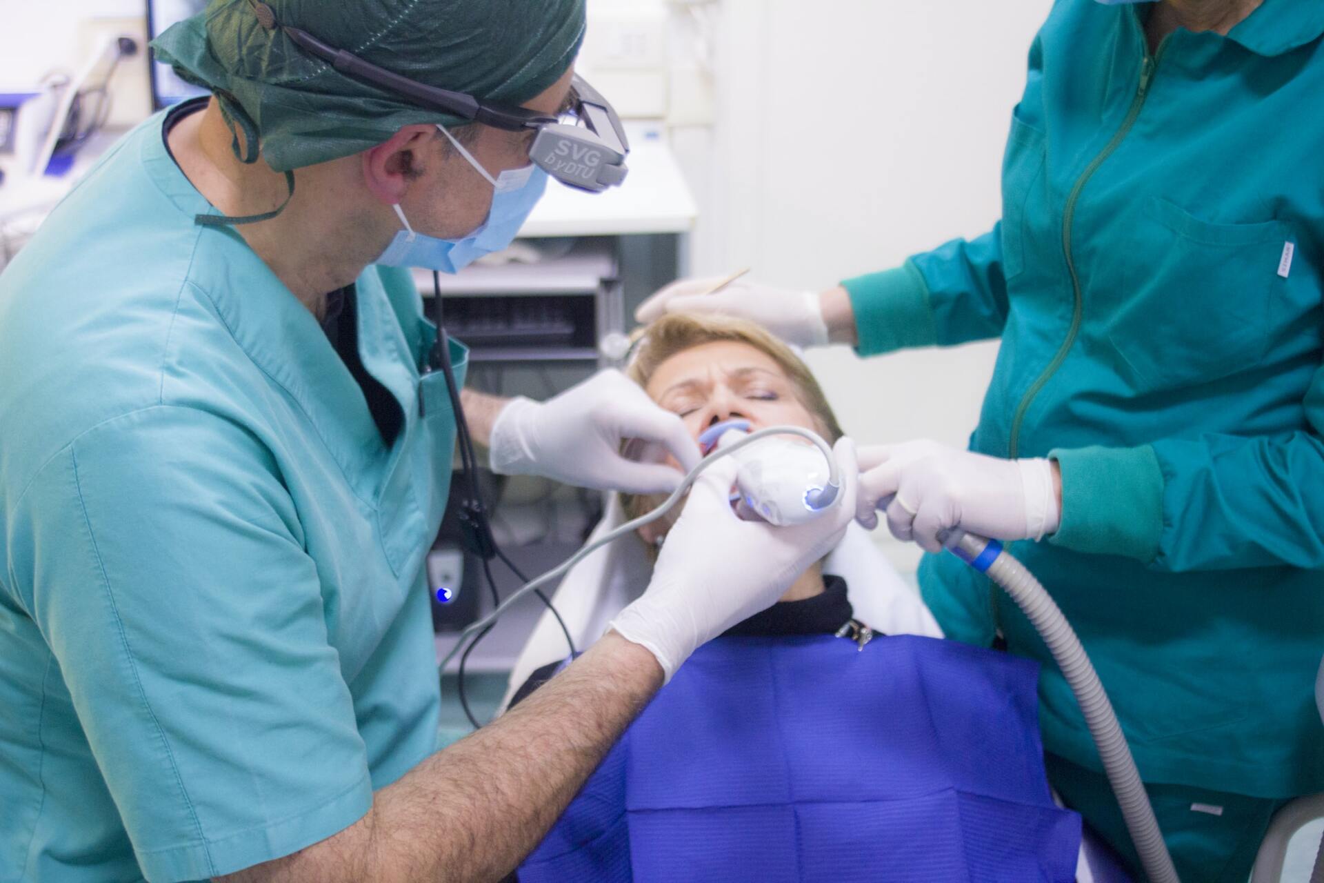 A dentist is examining a patient 's teeth in a dental office.