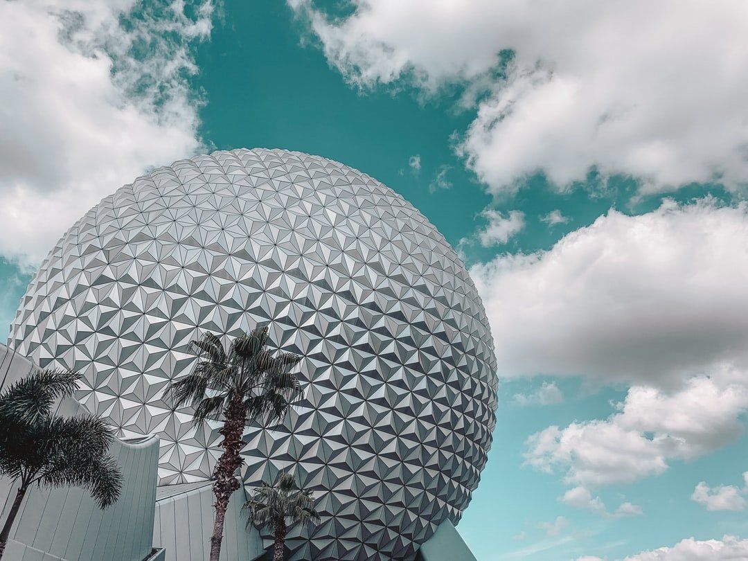 A large dome shaped building with palm trees in front of it.