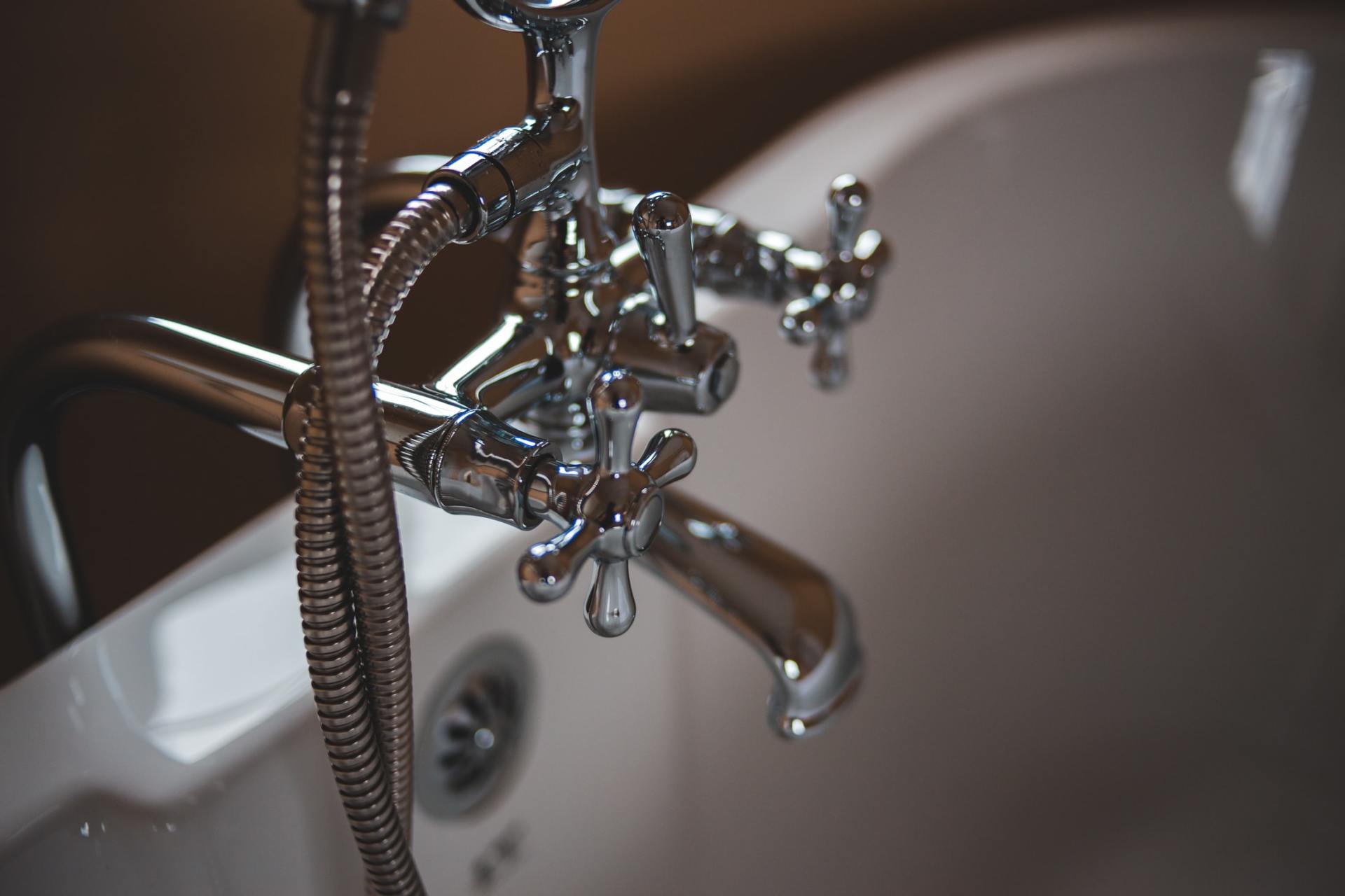 A close up of a bathtub with a shower head attached to it.