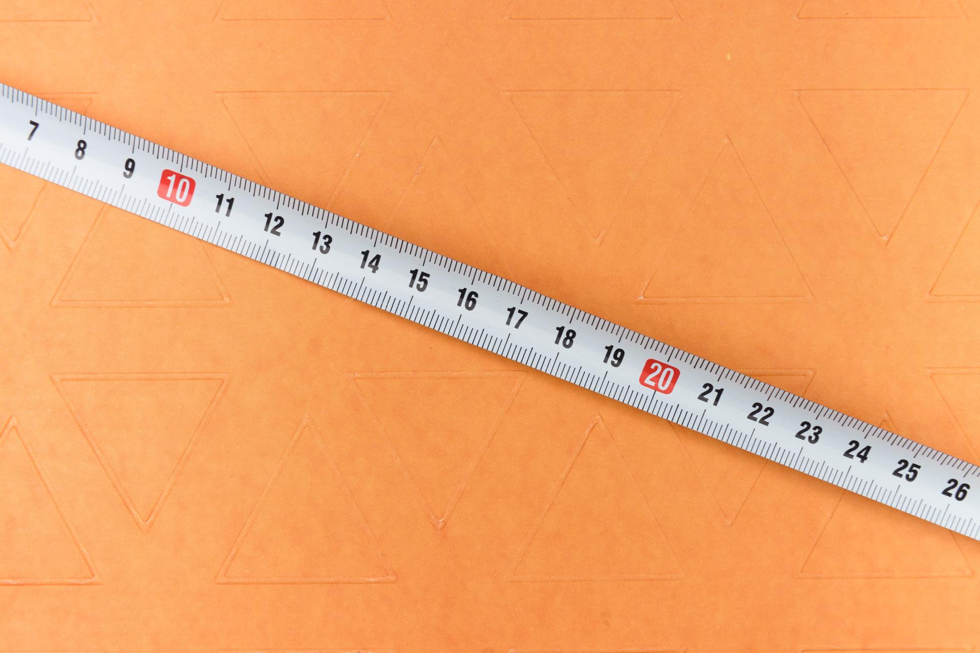 tape measurer against an orange background