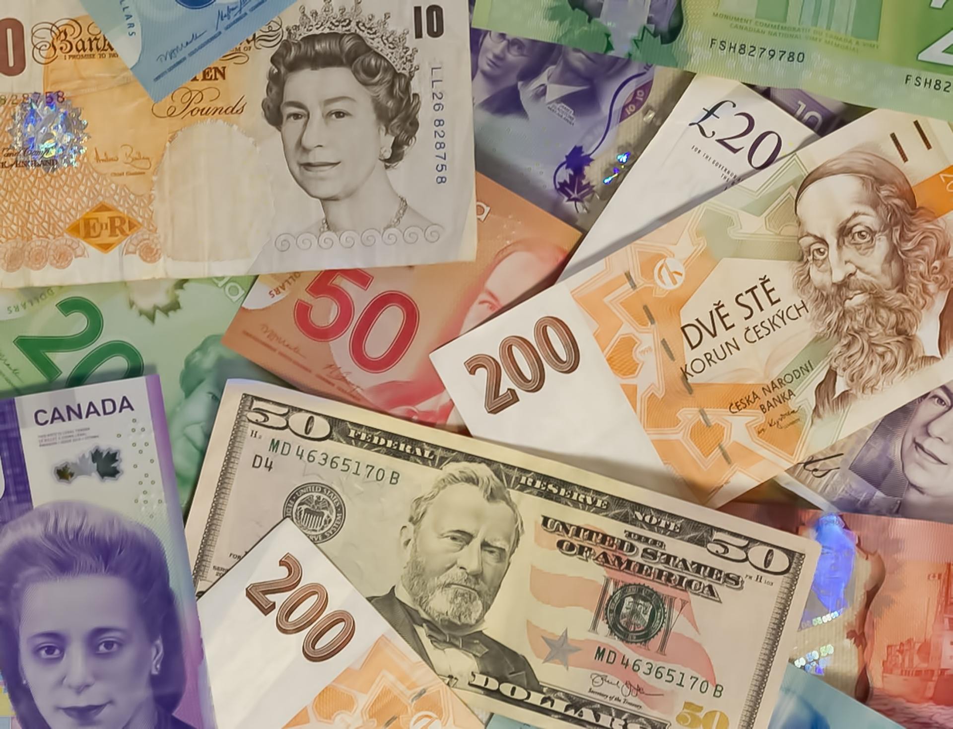 Assorted international banknotes, including US dollars, British pounds, and Canadian dollars.