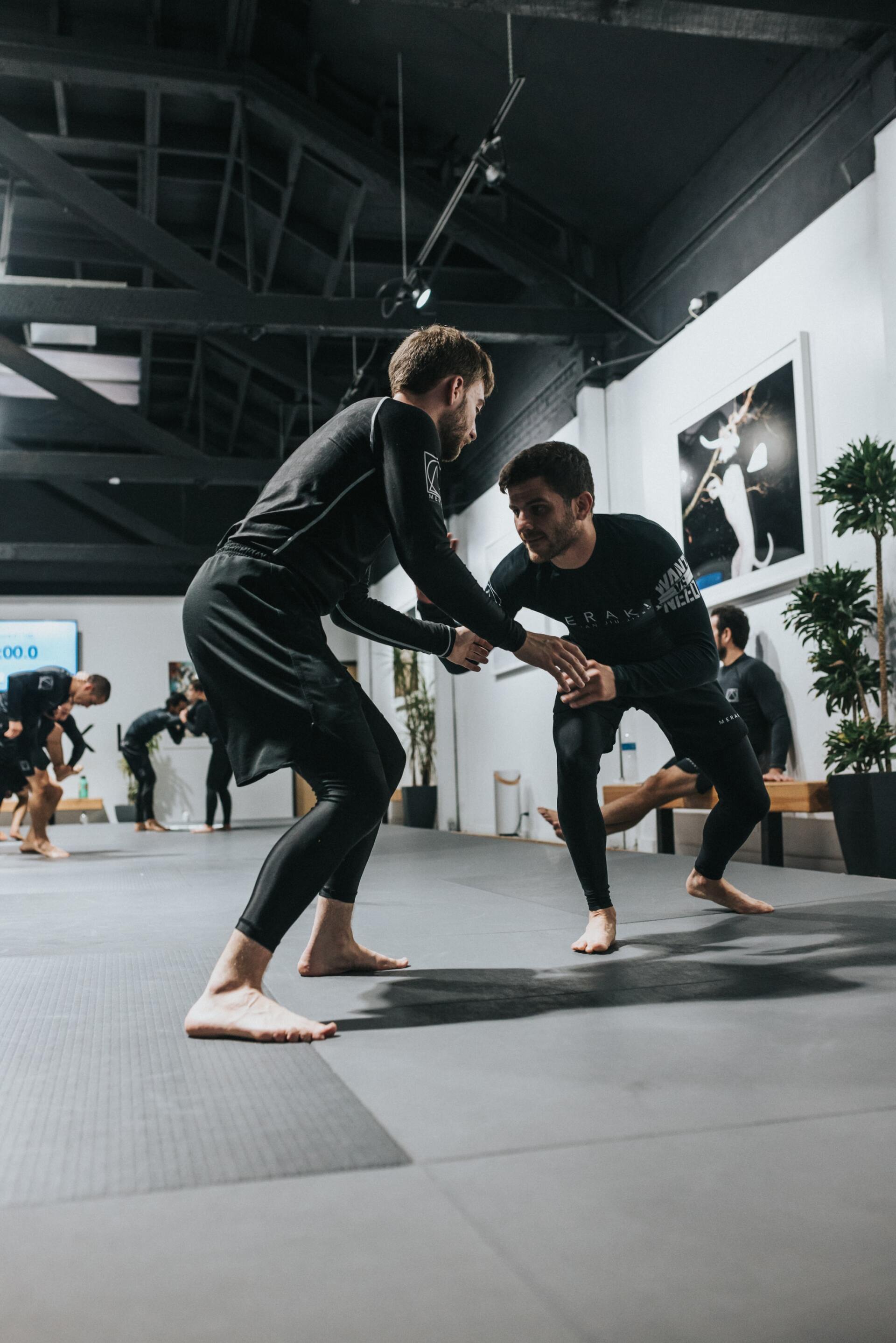 A group of men are practicing martial arts in a gym.