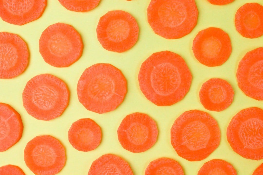 Abstract pattern of orange-red circular dots on a pale yellow background