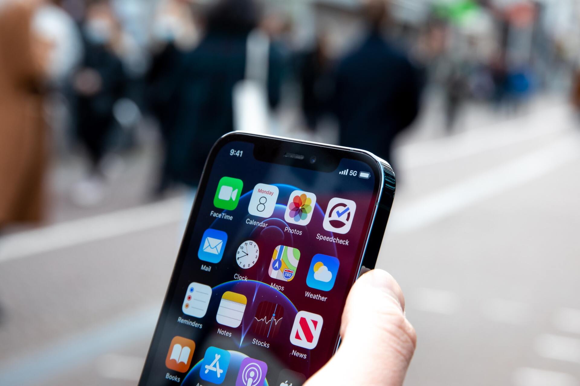 A person is holding a cell phone looking at mobile apps