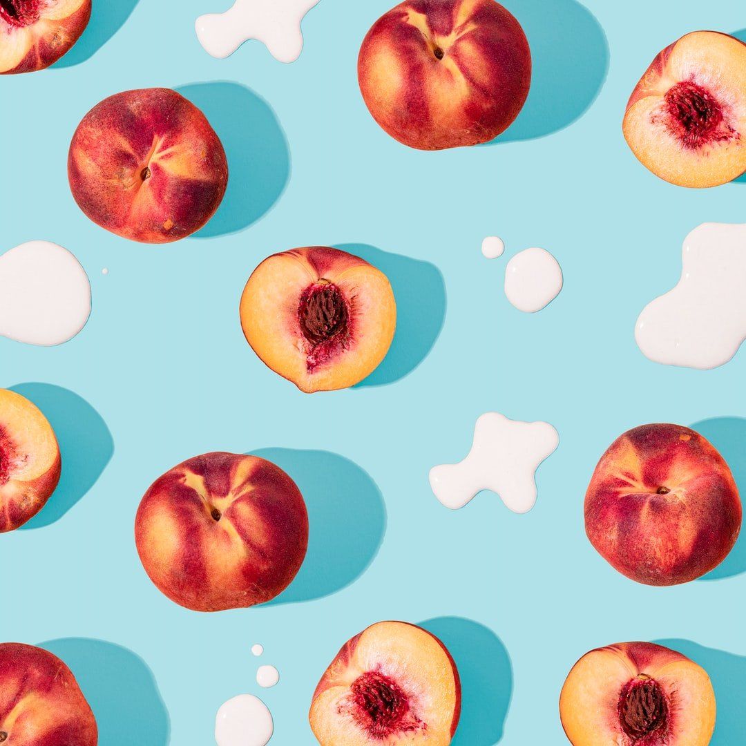 Peaches scattered on a light blue background with white splash shapes