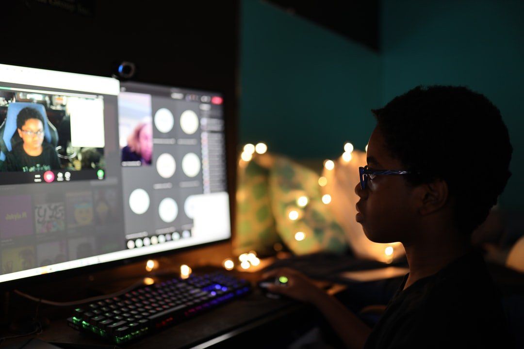 A person is sitting in front of a computer monitor.