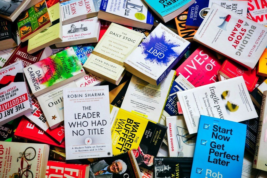 A pile of books including one titled start now get perfect later